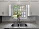 Kitchen sink overlooking backyard with granite countertops and a tile backsplash for a modern feel at 30 Court, Ellenwood, GA 30294