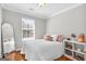 Stylish bedroom featuring a white bed, white shelves, pink accents, a mirror, and a window with blinds at 420 Heritage Park Nw Trce # 22, Kennesaw, GA 30144