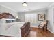 Cozy bedroom with a decorative wooden bed frame, plush bedding, and a chair by the window, ideal for relaxation at 420 Heritage Park Nw Trce # 22, Kennesaw, GA 30144