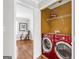 Convenient laundry area featuring a red washer and dryer set, with a shelving unit for storage and easy access at 420 Heritage Park Nw Trce # 22, Kennesaw, GA 30144