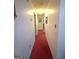 Long hallway with neutral walls and red carpet, offering access to multiple rooms at 7133 Babbling Brook Dr, Jonesboro, GA 30236