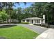 Beautiful single-story home with mature trees, gravel driveway, and lush green lawn at 2676 Cottonwood Dr, Marietta, GA 30066