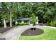 Inviting front yard with circular driveway, landscaped flowerbeds, mature trees, and lush green lawn surrounding the home at 2676 Cottonwood Dr, Marietta, GA 30066
