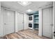 Laundry room with stacked washer and dryer, storage shelves, wood-look floor, and white doors at 2676 Cottonwood Dr, Marietta, GA 30066