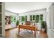 Bright living room featuring hardwood floors and large windows overlooking a green landscape, decorated with a desk at 2676 Cottonwood Dr, Marietta, GA 30066