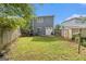 Backyard featuring a two-story home, a storage shed, wood fence, and green grass at 4706 Cedar Park Trl, Stone Mountain, GA 30083