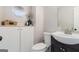 Modern half bathroom with dark vanity, white toilet, sink, and a decorative wall cabinet at 4706 Cedar Park Trl, Stone Mountain, GA 30083