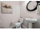 This powder room boasts a modern pedestal sink, round mirror, and stylish neutral paint at 1271 Mackintosh Nw Park # 30, Atlanta, GA 30318