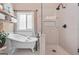 Bright bathroom featuring a freestanding tub and glass enclosed shower with white subway tile and neutral color palette at 264 Line Creek Cir, Sharpsburg, GA 30277