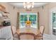 This dining room has a table with four chairs next to a window with a backyard view at 264 Line Creek Cir, Sharpsburg, GA 30277