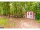 Red outbuilding with a white star detail on the double doors in a wooded area at 264 Line Creek Cir, Sharpsburg, GA 30277