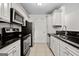 Updated kitchen with stainless steel appliances, white cabinets, and dark granite countertops at 5207 Santa Fe Pkwy, Sandy Springs, GA 30350