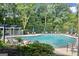 A serene community pool surrounded by mature trees offers a refreshing escape, perfect for relaxation and recreation at 5207 Santa Fe Pkwy, Sandy Springs, GA 30350