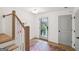 Bright foyer with hardwood floors, light gray door, modern lighting, and a staircase with white railing at 698 Eustace Se St, Atlanta, GA 30315