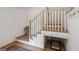 Staircase with hardwood steps, white risers, a stylish runner rug, and storage space underneath the landing at 698 Eustace Se St, Atlanta, GA 30315