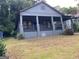 Quaint gray bungalow showcasing a welcoming front porch, carport, and well-established landscaping at 1053 Metropolitan Parkway Southwest Sw Pkwy, Atlanta, GA 30310