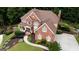 Aerial view of a landscaped home with brick exterior, manicured lawn, and spacious driveway at 200 Long Needle Ct, Sugar Hill, GA 30518