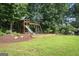 Fun backyard featuring a wooden playset with a slide, swings, and a grassy lawn at 200 Long Needle Ct, Sugar Hill, GA 30518