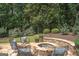 Seating area around the stone backyard fire pit; ideal for gatherings and outdoor relaxation at 200 Long Needle Ct, Sugar Hill, GA 30518
