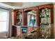 This home features a bar with wooden cabinets, shelving, wine storage and a mini refrigerator at 200 Long Needle Ct, Sugar Hill, GA 30518