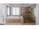 Bathroom featuring a glass shower and soaking tub with tiled surround at 200 Long Needle Ct, Sugar Hill, GA 30518