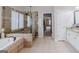 Bathroom features a glass enclosed shower, soaking tub, tile floor and vanity with granite counters at 200 Long Needle Ct, Sugar Hill, GA 30518