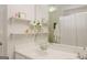 Bright bathroom featuring a double vanity with decor on floating shelves and a shower with a curtain at 200 Long Needle Ct, Sugar Hill, GA 30518