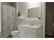 This bathroom features a vanity with a mirror, toilet, and shower with a paisley shower curtain at 200 Long Needle Ct, Sugar Hill, GA 30518