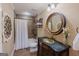 Elegant bathroom featuring a marble-topped vanity, decorative mirror, and tiled shower for a luxurious feel at 200 Long Needle Ct, Sugar Hill, GA 30518