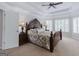 Spacious bedroom features carpeted floors, a trey ceiling with fan, and windows with wooden shutters at 200 Long Needle Ct, Sugar Hill, GA 30518