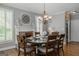 Elegant dining room featuring a stone fireplace, wood floors, and stylish chandelier at 200 Long Needle Ct, Sugar Hill, GA 30518