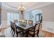 Formal dining room with rich wood table, elegant chandelier, and beautiful trim at 200 Long Needle Ct, Sugar Hill, GA 30518