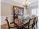 Formal dining room with rich wood table, elegant chandelier, and wainscoting details at 200 Long Needle Ct, Sugar Hill, GA 30518