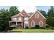Charming brick home featuring manicured lawn, complementing shrubbery, and a welcoming entrance at 200 Long Needle Ct, Sugar Hill, GA 30518