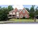 Charming two-story brick home with a welcoming front porch and well-manicured landscaping at 200 Long Needle Ct, Sugar Hill, GA 30518