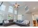 Bright living room featuring large windows, tall ceilings, and a cozy ceiling fan at 200 Long Needle Ct, Sugar Hill, GA 30518
