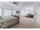 Large main bedroom features a seating area, carpeted floors and windows with wooden shutters at 200 Long Needle Ct, Sugar Hill, GA 30518