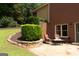 Brick patio with stone accents, a bistro table, and lush landscaping creates a private outdoor oasis at 200 Long Needle Ct, Sugar Hill, GA 30518