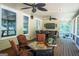 Large, inviting screened porch with a fire table, ceiling fans, and a peaceful view at 200 Long Needle Ct, Sugar Hill, GA 30518