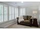 Sitting area includes sofa with throw blanket and windows dressed with wooden shutters at 200 Long Needle Ct, Sugar Hill, GA 30518