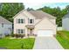 Tan, two-story home with a two-car garage, and landscaped front yard at 232 Shelton Cir, Temple, GA 30179