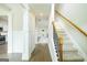 Bright foyer with hardwood floors, staircase, and decorative columns leading to an open floor plan at 232 Shelton Cir, Temple, GA 30179