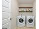 Laundry room with washer, dryer, shelving and a white door, complete with tile flooring at 232 Shelton Cir, Temple, GA 30179