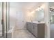 A bathroom featuring a tiled floor, double sink vanity with gray cabinets, and a separate shower and bathtub at 129 Academy Ln, Canton, GA 30114