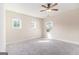 An empty carpeted bedroom with neutral walls featuring bright windows and a ceiling fan with lighting at 129 Academy Ln, Canton, GA 30114