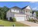 Side view of white two-story home, featuring an attached two-car garage and well-maintained lawn at 129 Academy Ln, Canton, GA 30114