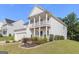 Angle shot of the white home with double porch, showing front yard landscaping at 129 Academy Ln, Canton, GA 30114