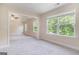 Bright living room featuring large windows, light colored walls and carpet, and an open concept to the connected room at 129 Academy Ln, Canton, GA 30114