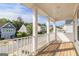 A covered porch offering neighborhood views through its white railing and columns at 129 Academy Ln, Canton, GA 30114