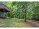 Exterior view of the backyard with a deck, mature trees and lush green ground cover at 5341 Terrytown Ln, Lithonia, GA 30038